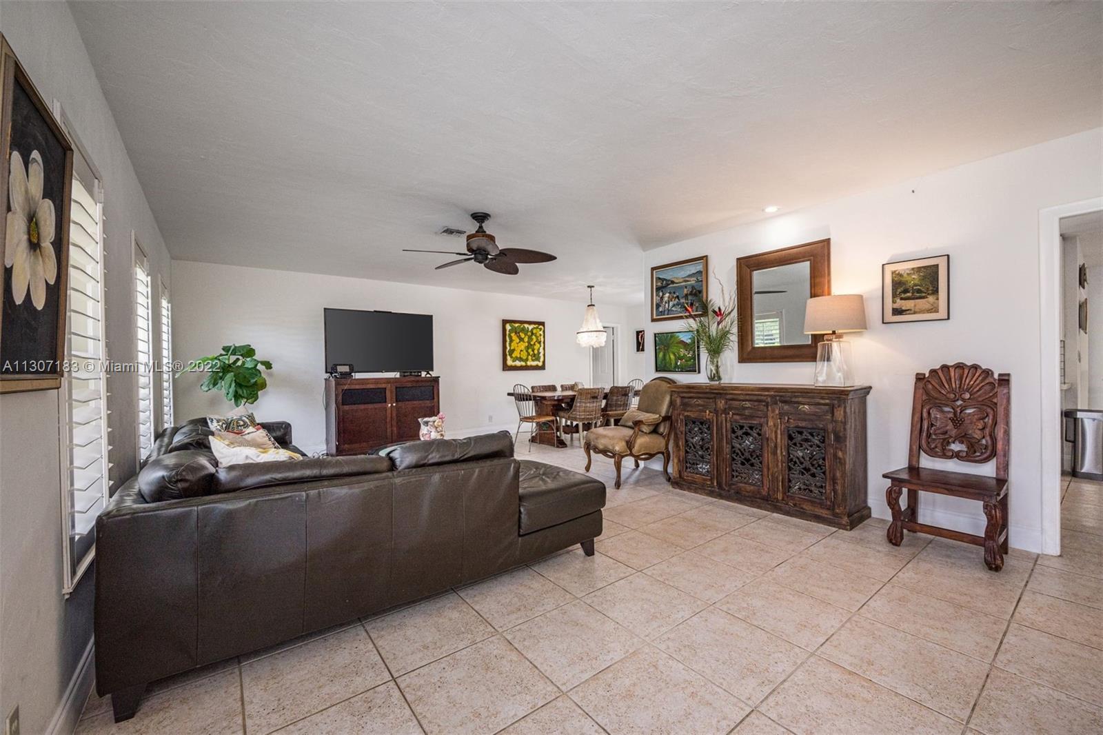 1592 Northwest 8th Street Boca Raton, FL 33486 - Photo 11 of 35 a living room with furniture and a flat screen tv