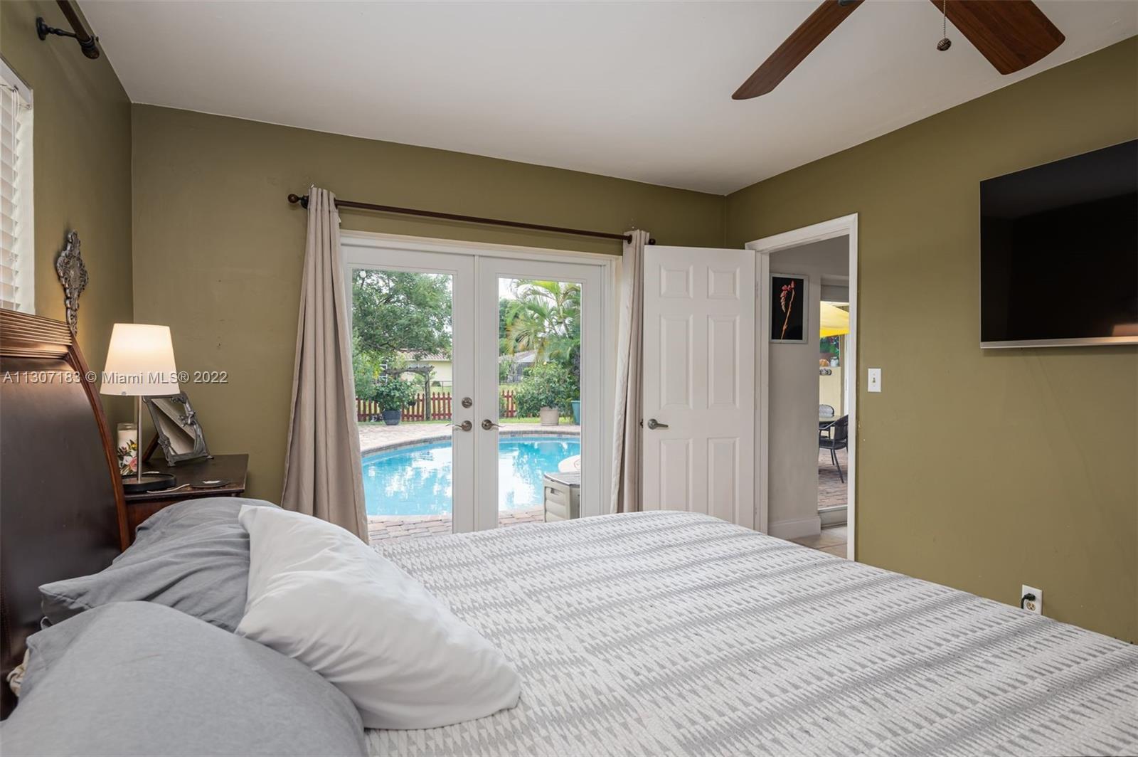 1592 Northwest 8th Street Boca Raton, FL 33486 - Photo 15 of 35 a bedroom with a large bed and flat tv screen on dresser