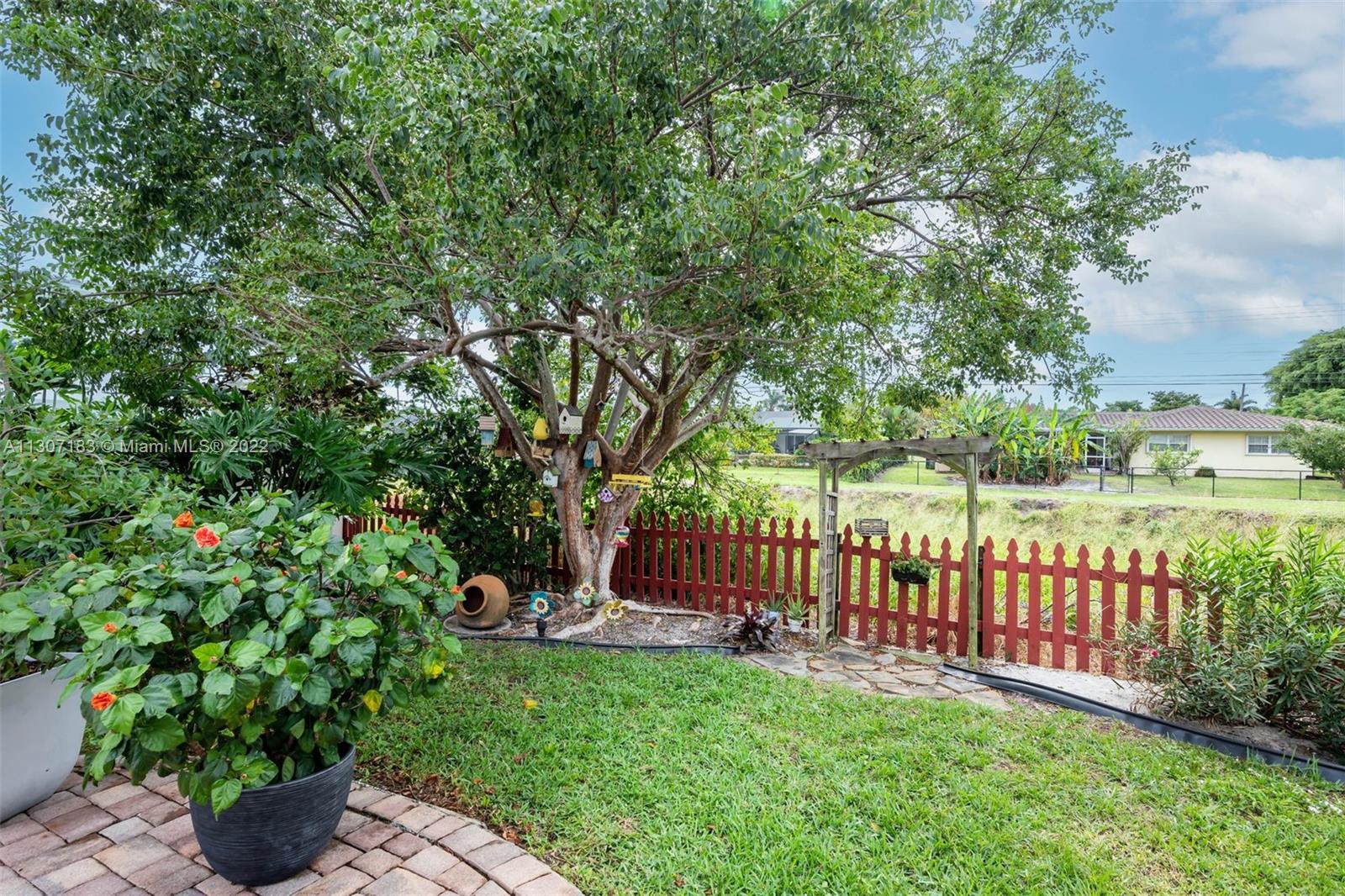 1592 Northwest 8th Street Boca Raton, FL 33486 - Photo 24 of 35 a view of a garden with a bench