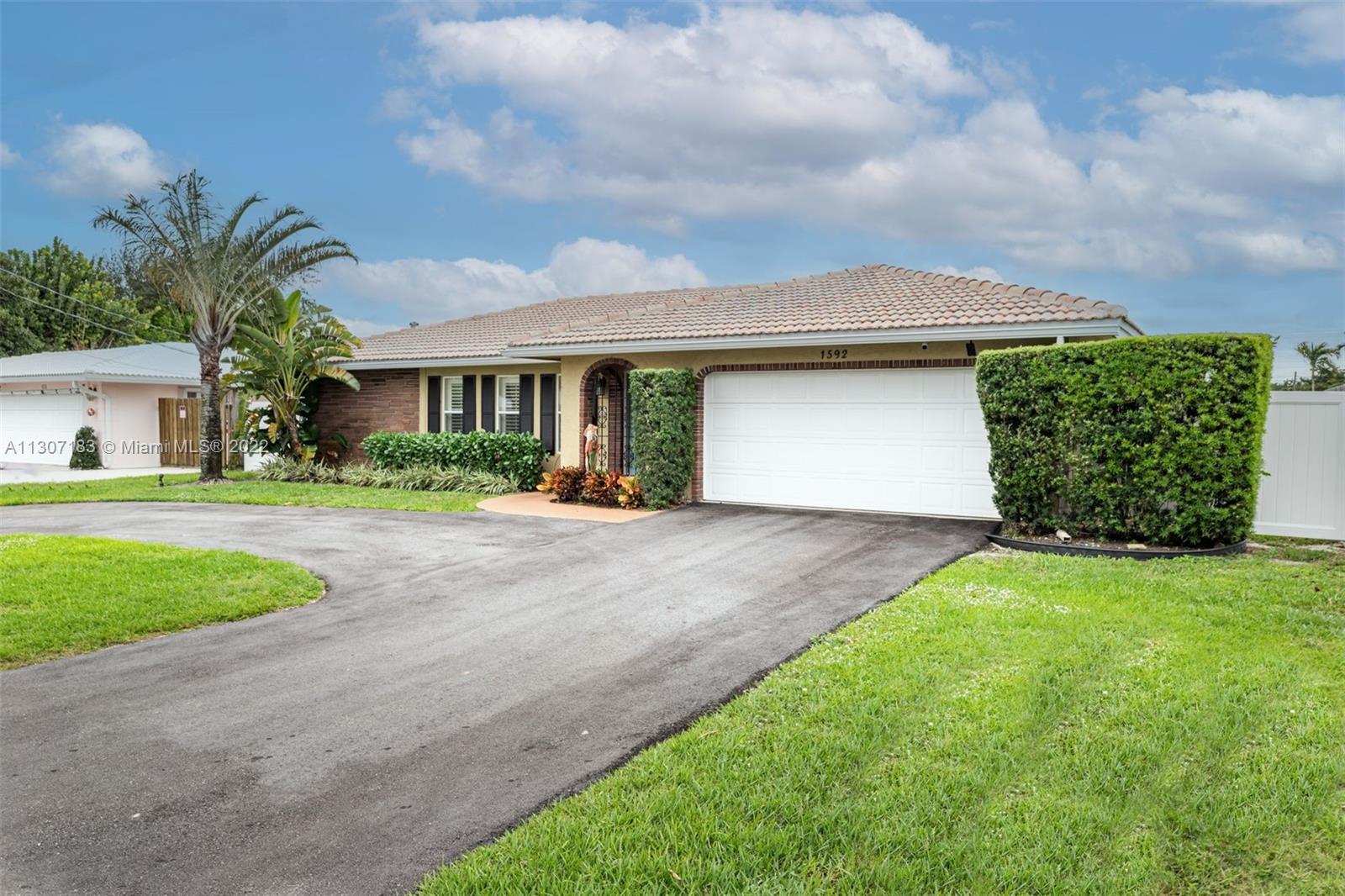 1592 Northwest 8th Street Boca Raton, FL 33486 - Photo 28 of 35 a front view of house with yard and green space