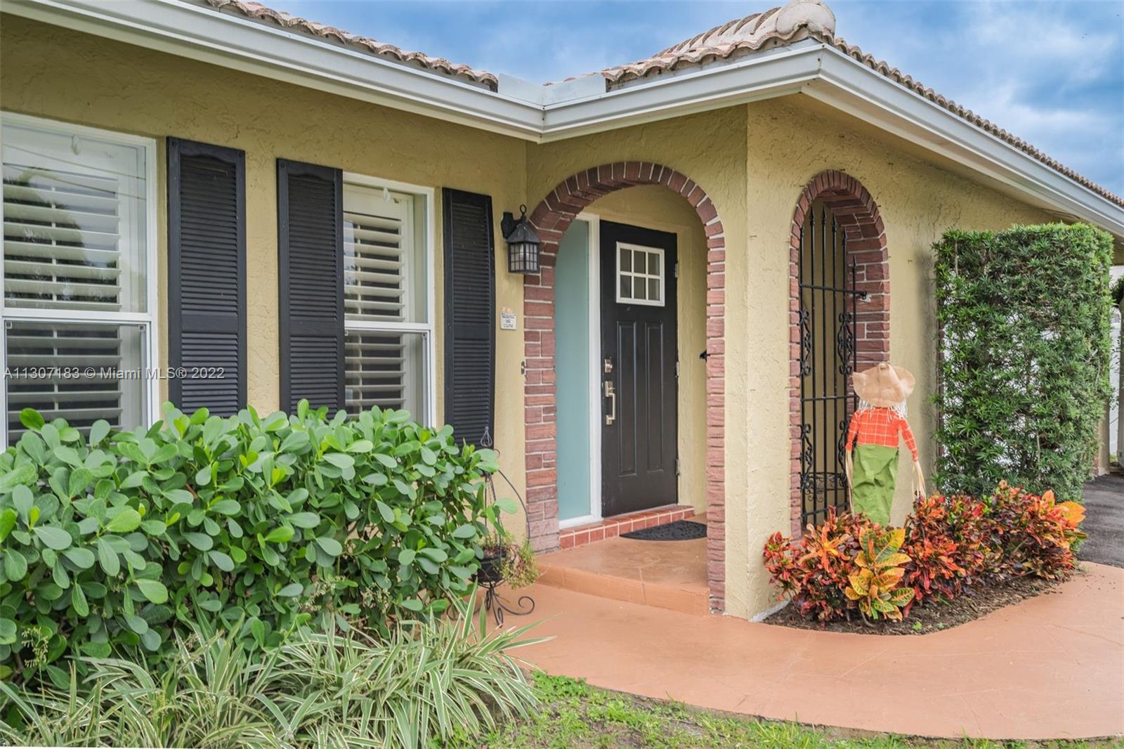 1592 Northwest 8th Street Boca Raton, FL 33486 - Photo 30 of 35 a front view of a house with a yard