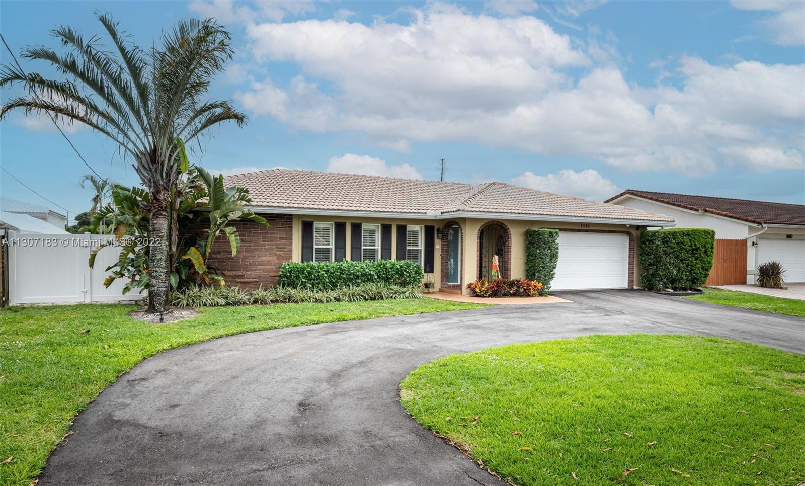 1592 Northwest 8th Street Boca Raton, FL 33486 - Photo 31 of 35 a front view of a house with a yard and porch