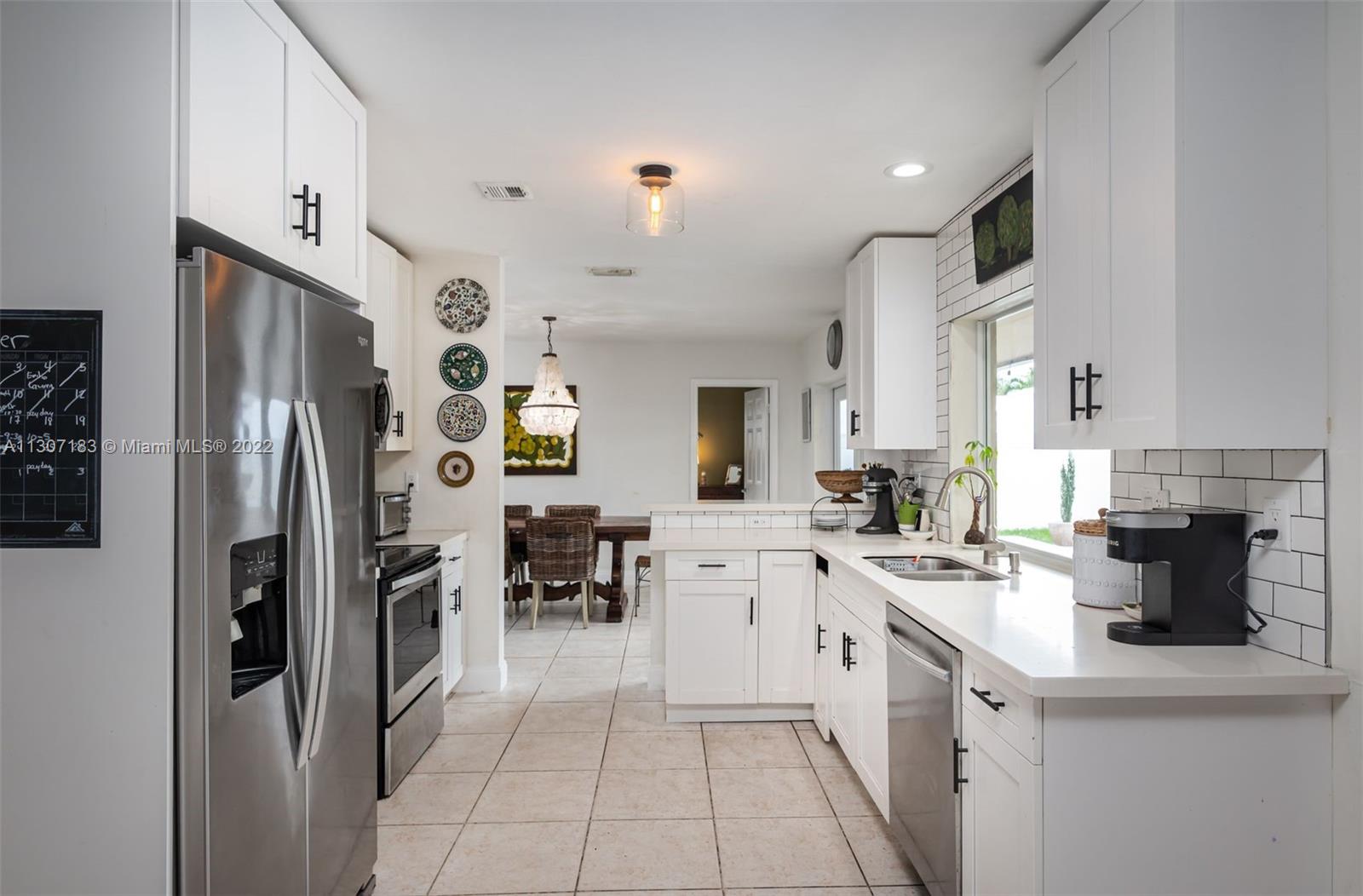 1592 Northwest 8th Street Boca Raton, FL 33486 - Photo 6 of 35 a kitchen with stainless steel appliances a refrigerator sink and cabinets