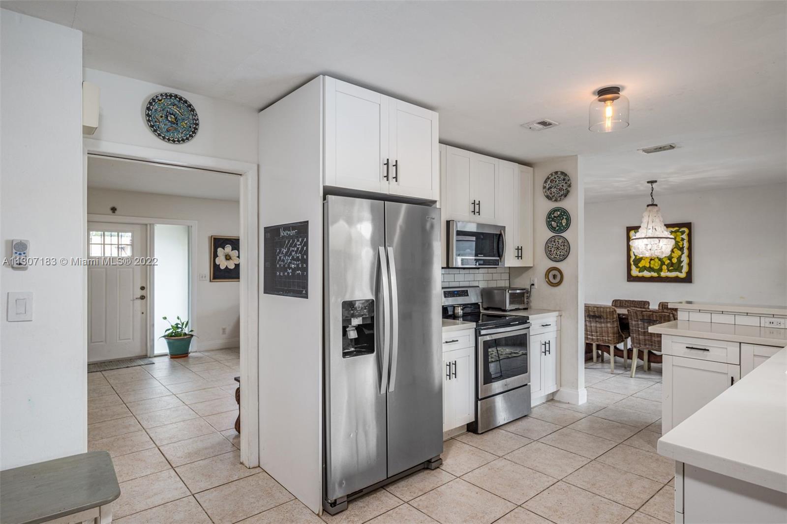 1592 Northwest 8th Street Boca Raton, FL 33486 - Photo 7 of 35 a kitchen with granite countertop a refrigerator and a stove top oven
