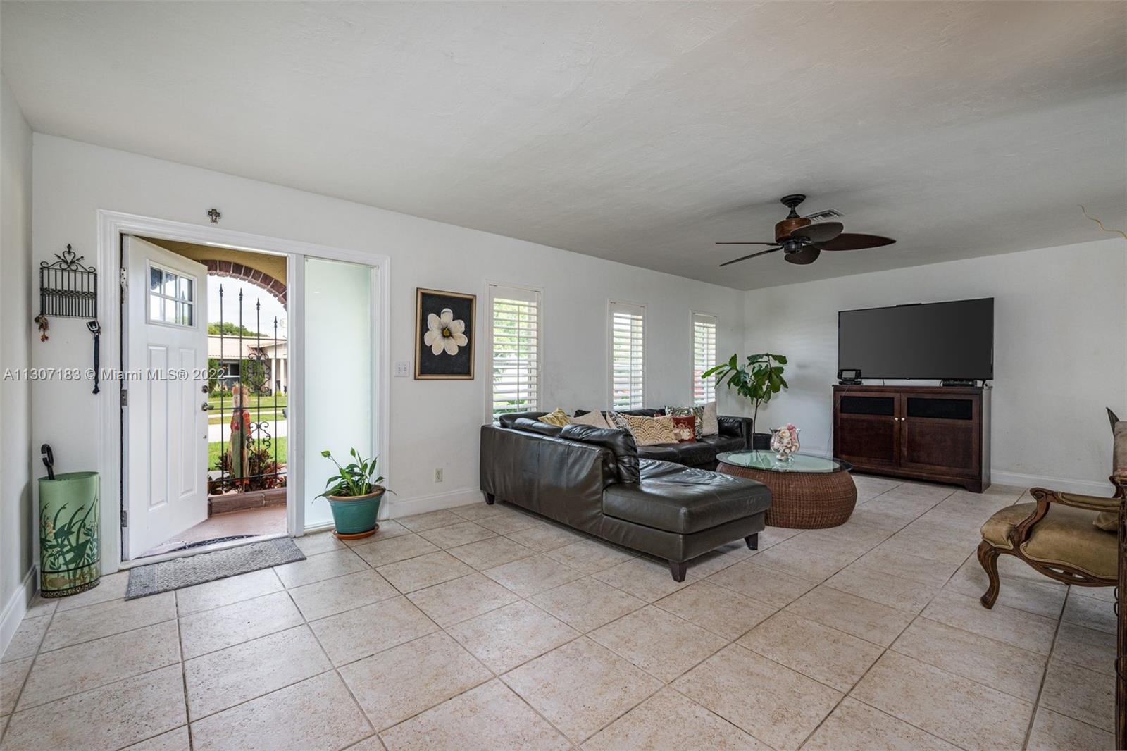 1592 Northwest 8th Street Boca Raton, FL 33486 - Photo 10 of 35 a living room with furniture and a flat screen tv