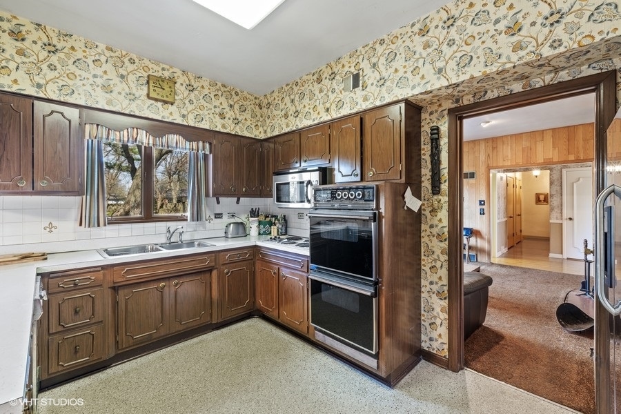 278 Longcommon Road Riverside, IL 60546 - Photo 12 of 36 a kitchen with stainless steel appliances granite countertop a stove a sink and a refrigerator