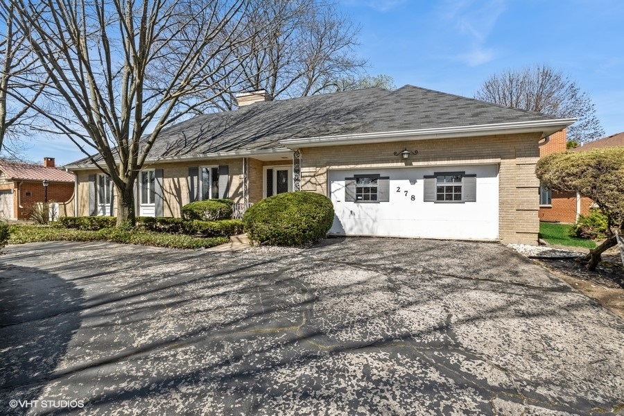 278 Longcommon Road Riverside, IL 60546 - Photo 2 of 36 a front view of a house with a yard and garage