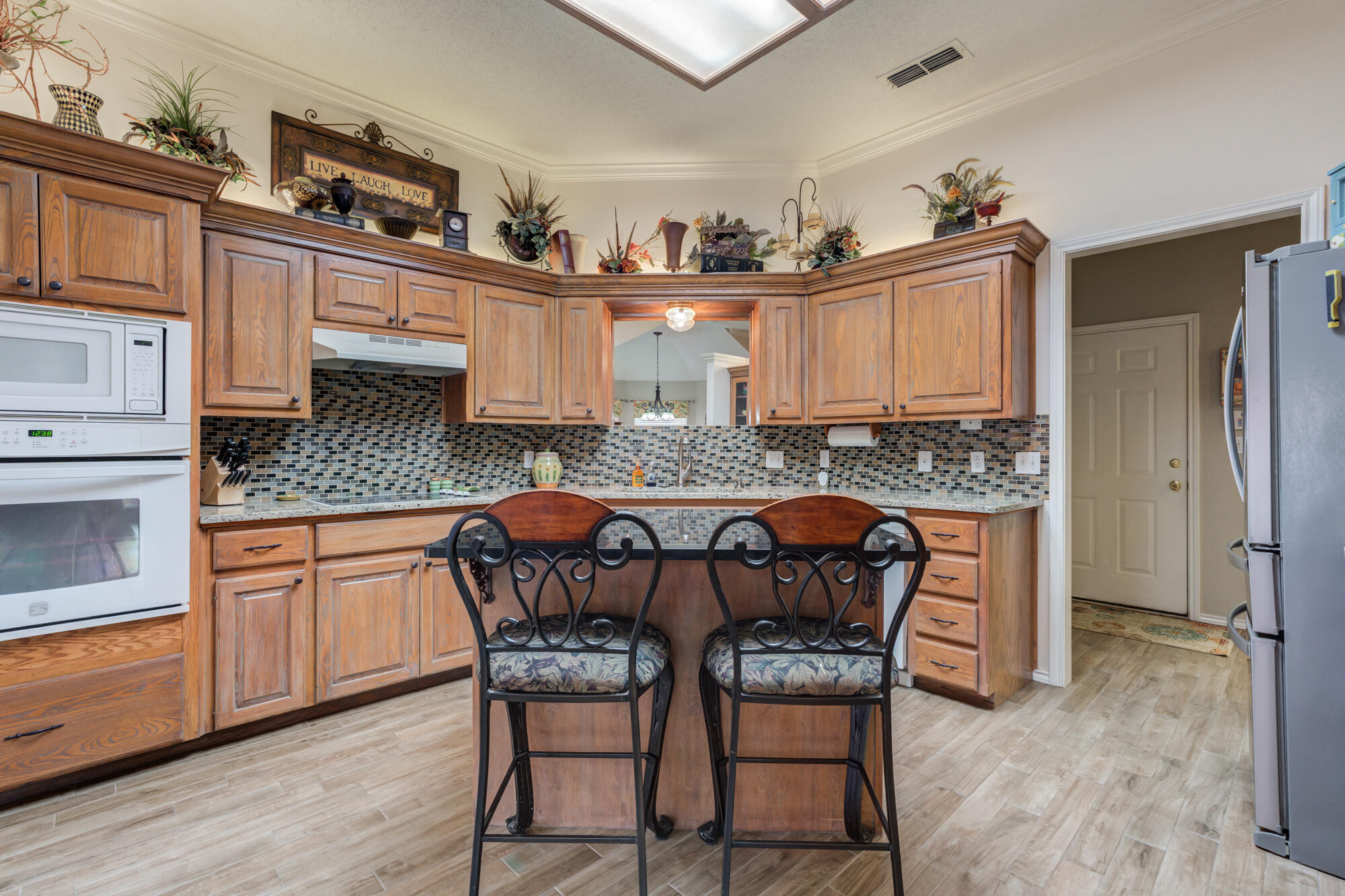 6908 Freeport Avenue Lubbock, TX 79424 - Photo 14 of 44 a kitchen with granite countertop a table chairs stove and cabinets