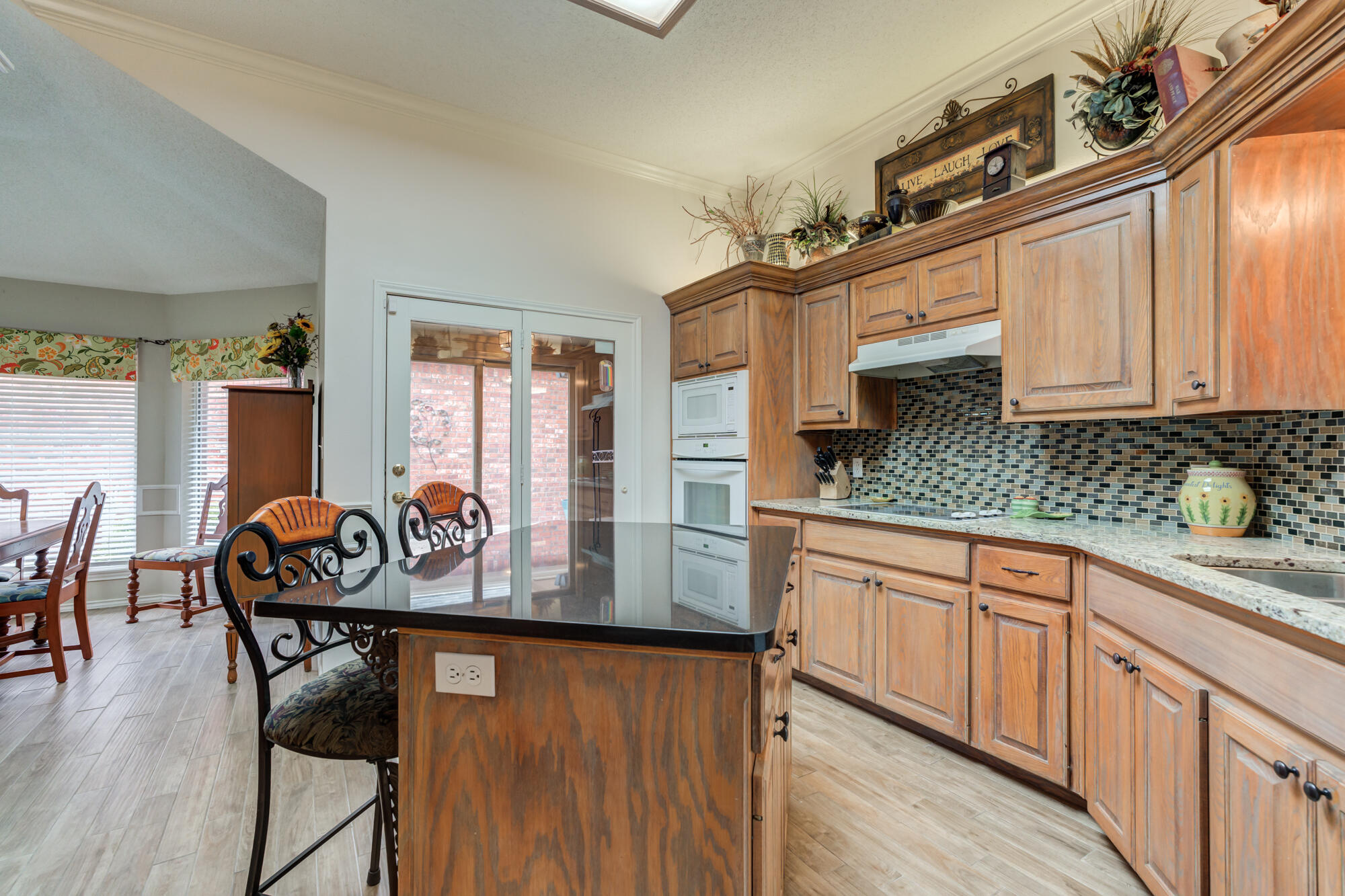 6908 Freeport Avenue Lubbock, TX 79424 - Photo 20 of 44 a kitchen with stainless steel appliances granite countertop a stove a sink dishwasher and cabinets with wooden floor