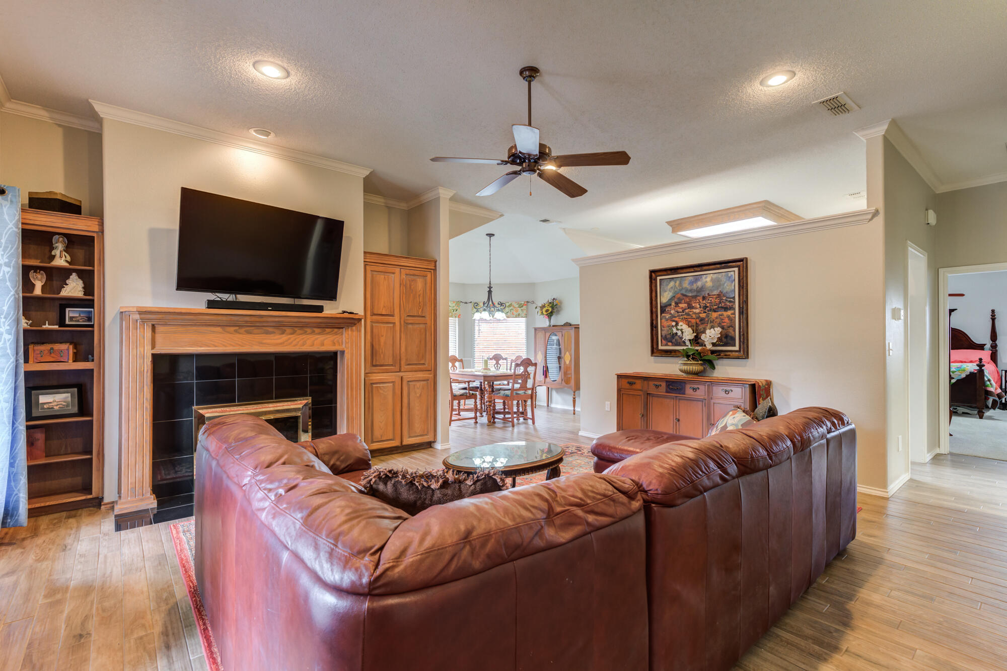 6908 Freeport Avenue Lubbock, TX 79424 - Photo 5 of 44 a living room with furniture a flat screen tv and a fireplace