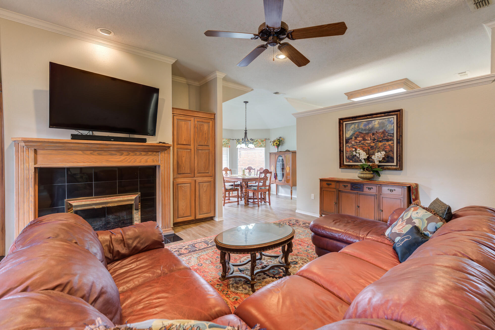 6908 Freeport Avenue Lubbock, TX 79424 - Photo 6 of 44 a living room with furniture a flat screen tv and a fireplace