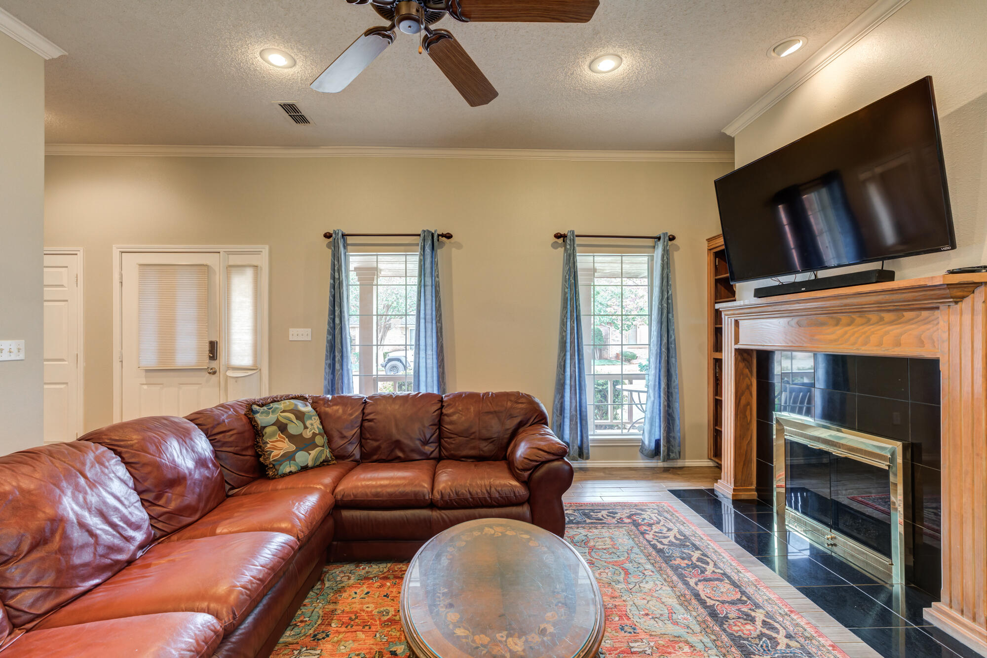6908 Freeport Avenue Lubbock, TX 79424 - Photo 9 of 44 a living room with a fireplace furniture and a flat screen tv