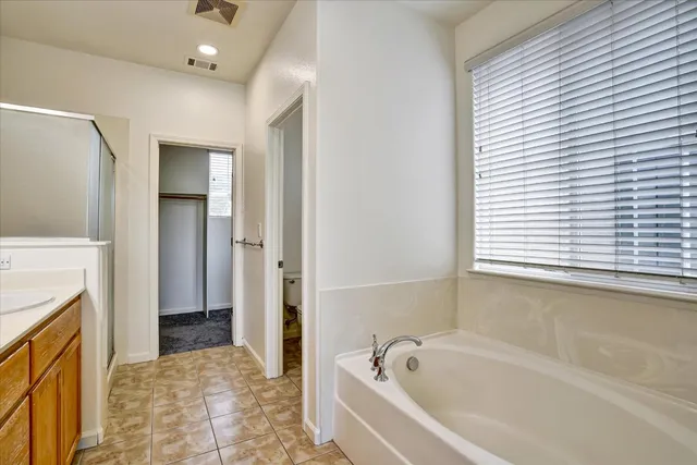 a bathroom with a granite countertop toilet a sink and a mirror