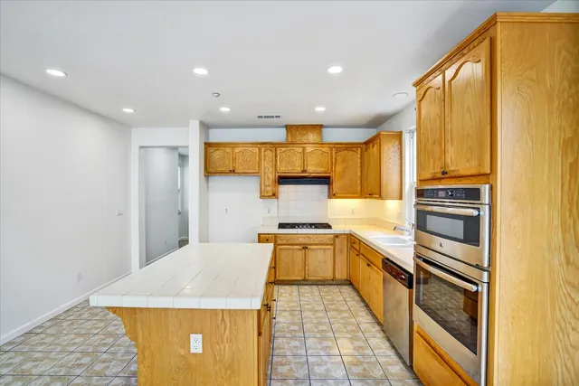 a kitchen with stainless steel appliances granite countertop a sink stove and cabinets