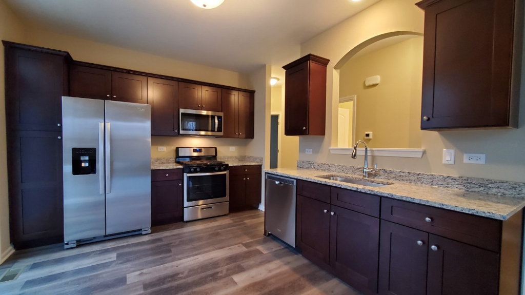 241 Timber Ridge Court Joliet, IL 60431 - Photo 7 of 14 a kitchen with stainless steel appliances granite countertop a refrigerator and a sink