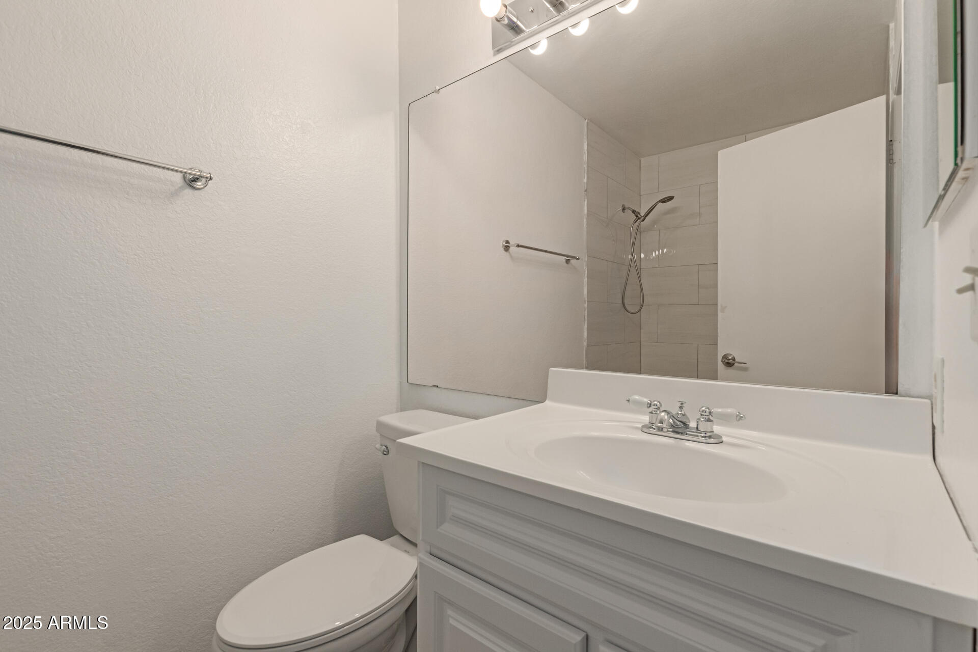 7977 West Wacker Road, Unit 244 Peoria, AZ 85381 - Photo 17 of 34 a bathroom with a sink mirror vanity and toilet