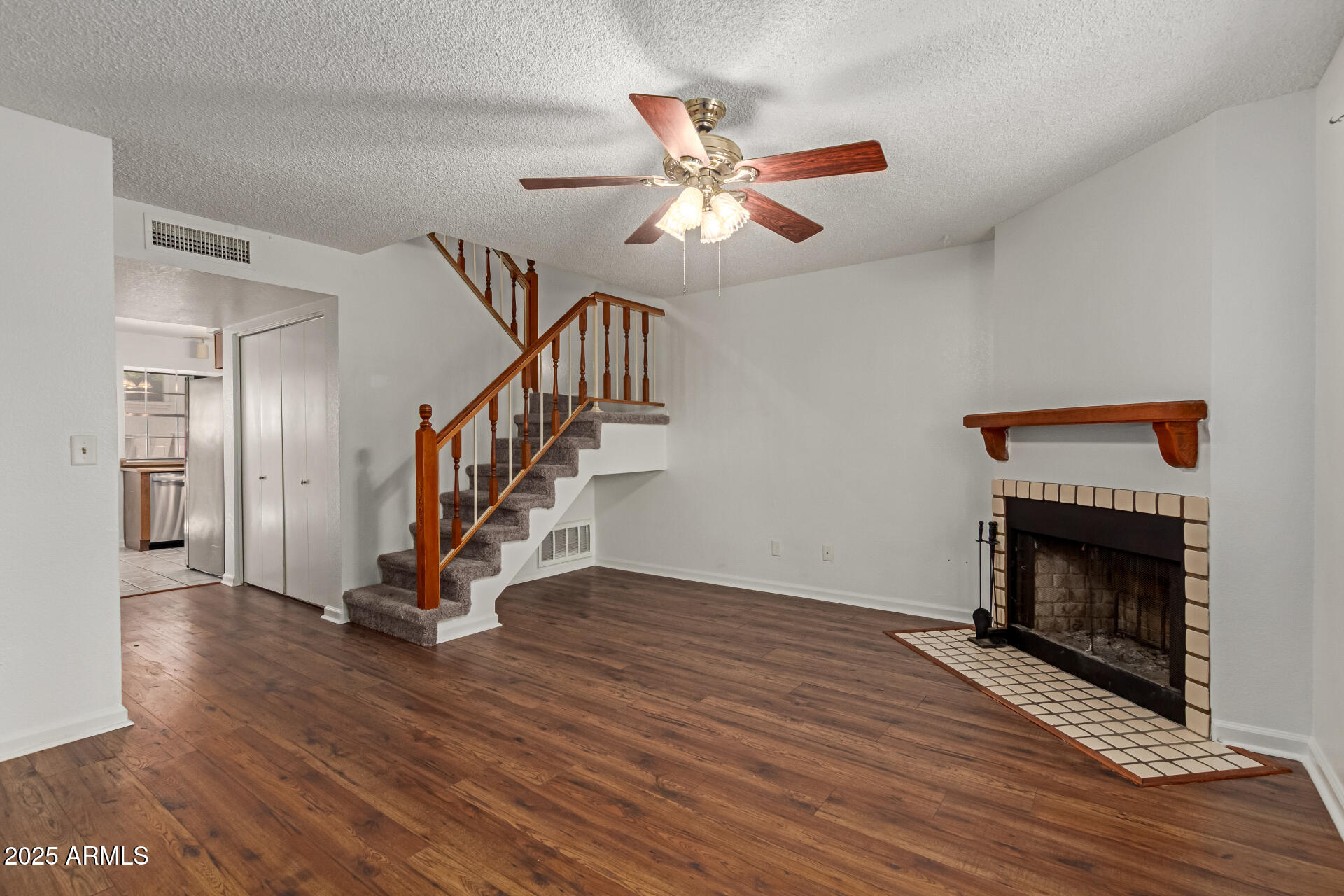 7977 West Wacker Road, Unit 244 Peoria, AZ 85381 - Photo 4 of 34 a view of empty room with wooden floor fan and a fireplace