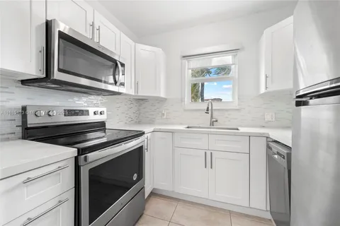 a kitchen with cabinets stainless steel appliances and sink