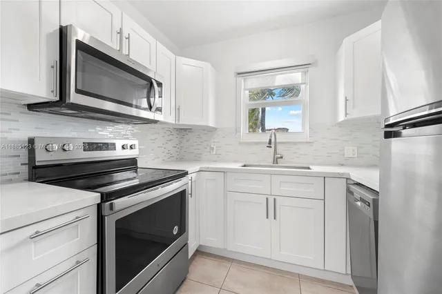 a kitchen with cabinets stainless steel appliances and sink