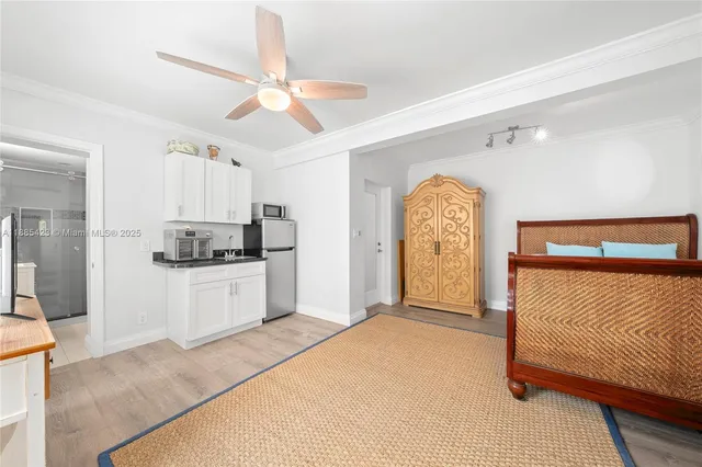 a kitchen with stainless steel appliances kitchen island a white cabinets and a chandelier