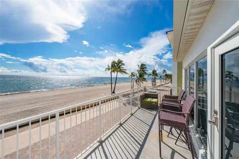 a view of a balcony with chairs and wooden floor