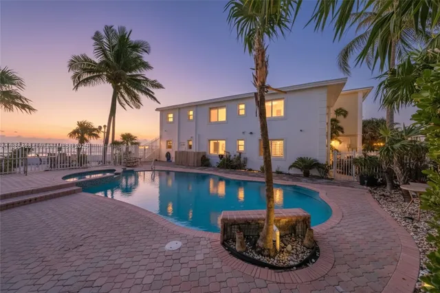 a house with palm tree next to a yard