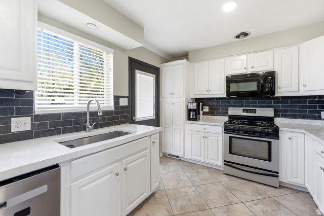 935 900 North Bountiful, UT 84010 - Photo 11 of 46 Kitchen featuring stainless steel appliances, light stone counters, white cabinetry, crown molding, and recessed lighting