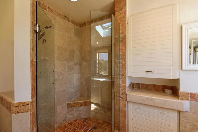 a bathroom with a granite countertop sink a mirror and shower
