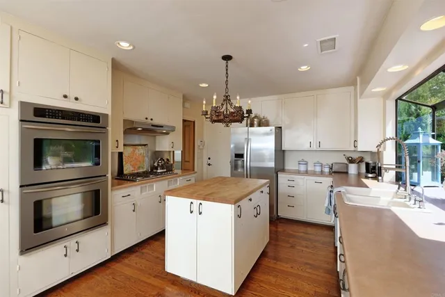 a kitchen with cabinets a sink and stainless steel appliances