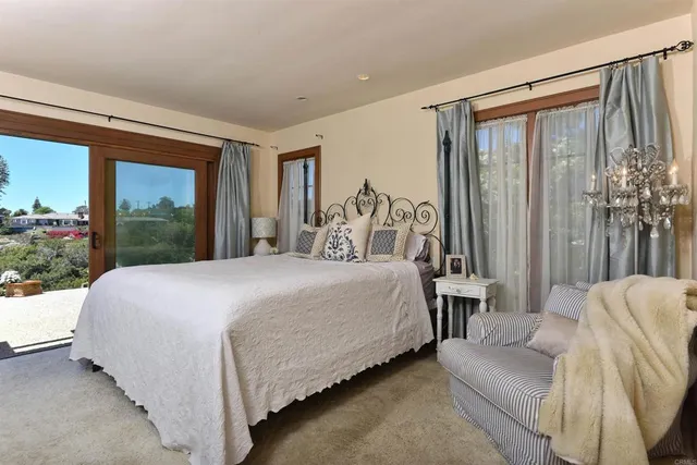 a bedroom with a bed lamp and a large window