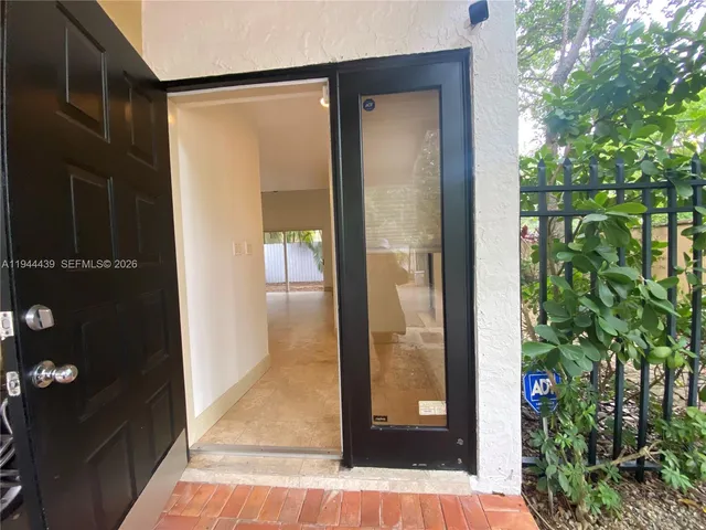 a view of a potted plant from a glass door
