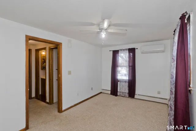 a view of an empty room with window and closet area