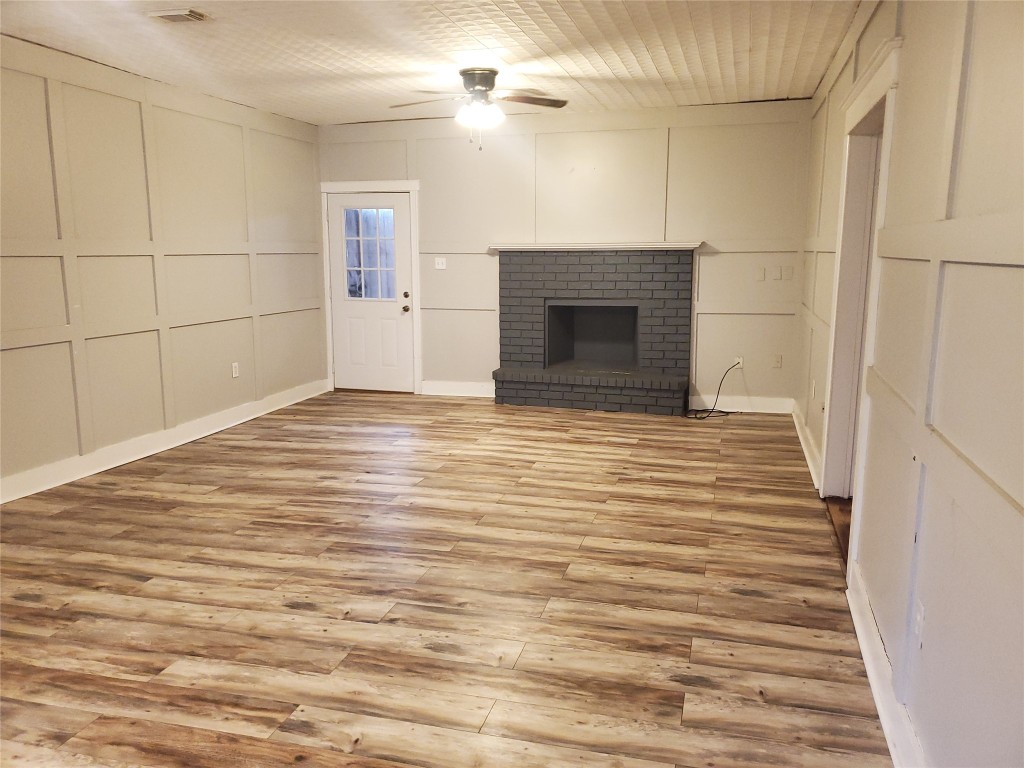 1233 Caldwell Road Angleton, TX 77515 - Photo 11 of 32 a view of empty room with wooden floor and fireplace