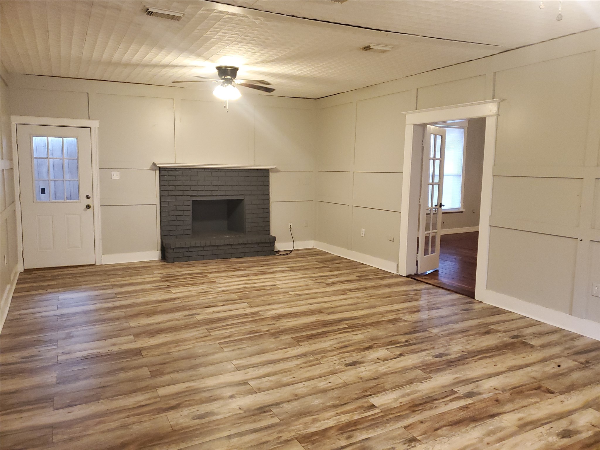 1233 Caldwell Road Angleton, TX 77515 - Photo 12 of 32 an empty room with wooden floor and fireplace