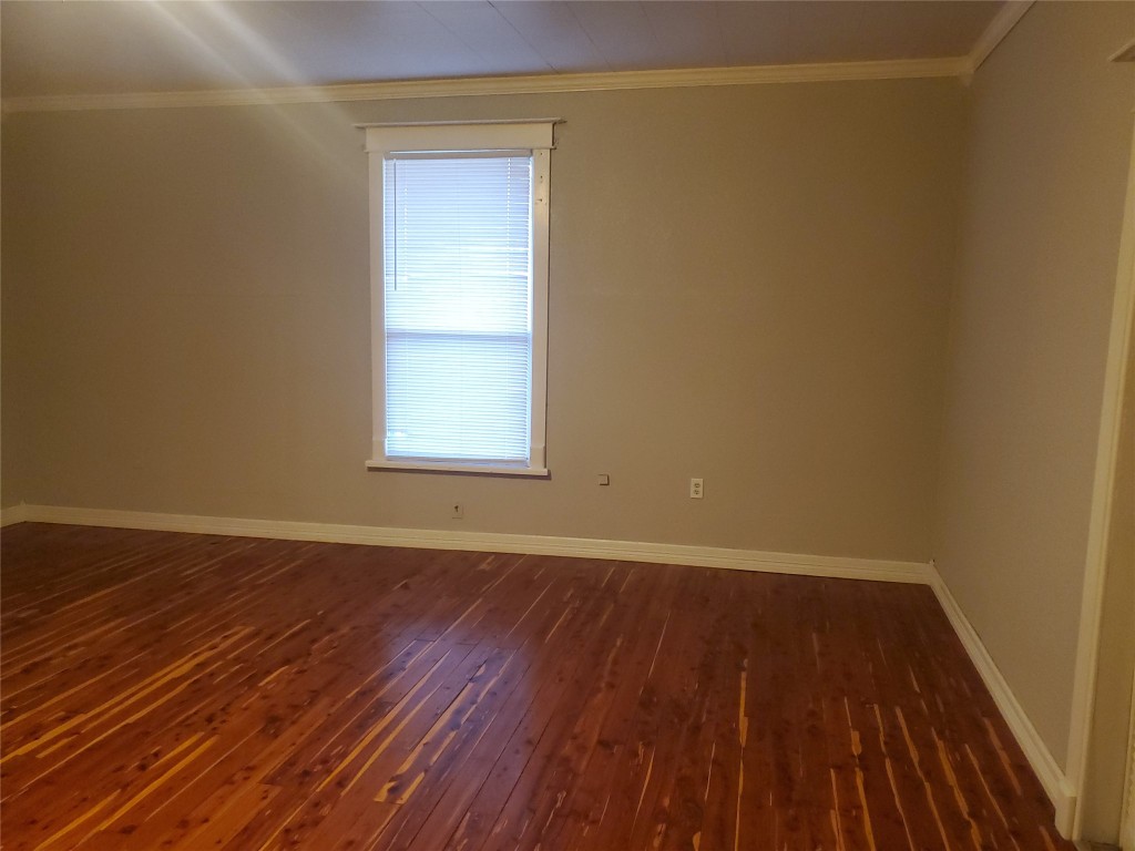 1233 Caldwell Road Angleton, TX 77515 - Photo 18 of 32 an empty room with wooden floor and windows