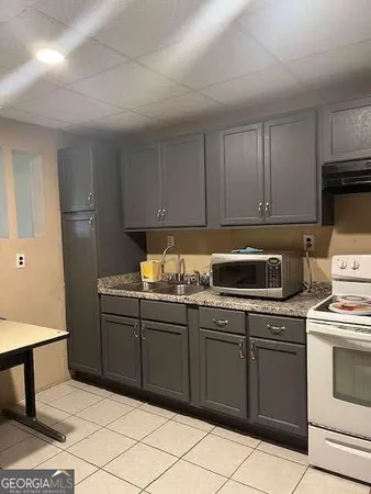 a kitchen with a stove sink and cabinets