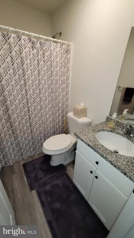 a bathroom with a granite countertop toilet and a sink