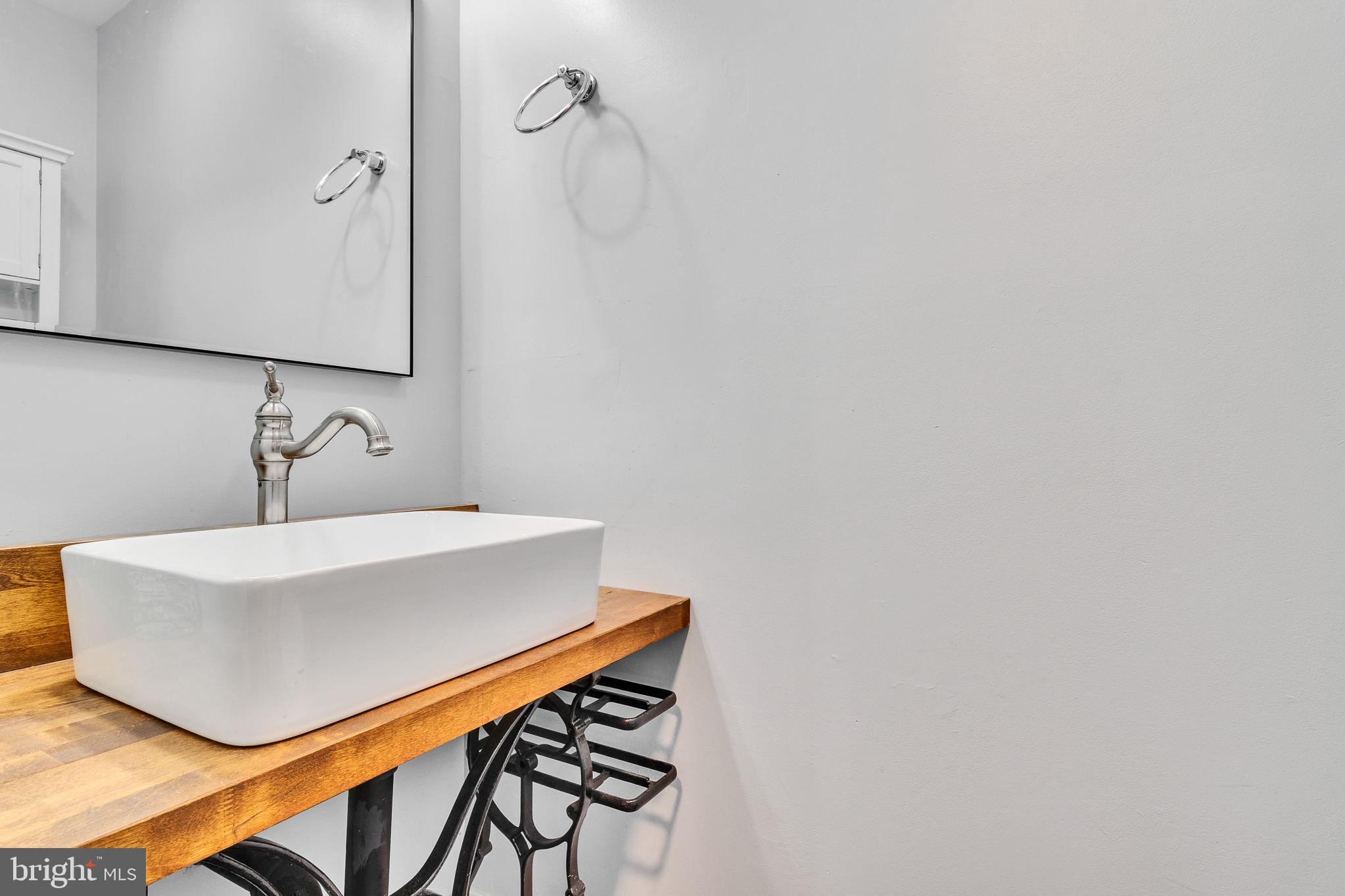 9832 River Road Lancaster, VA 22503 - Photo 23 of 68 Sleek modern sink with wooden accents.