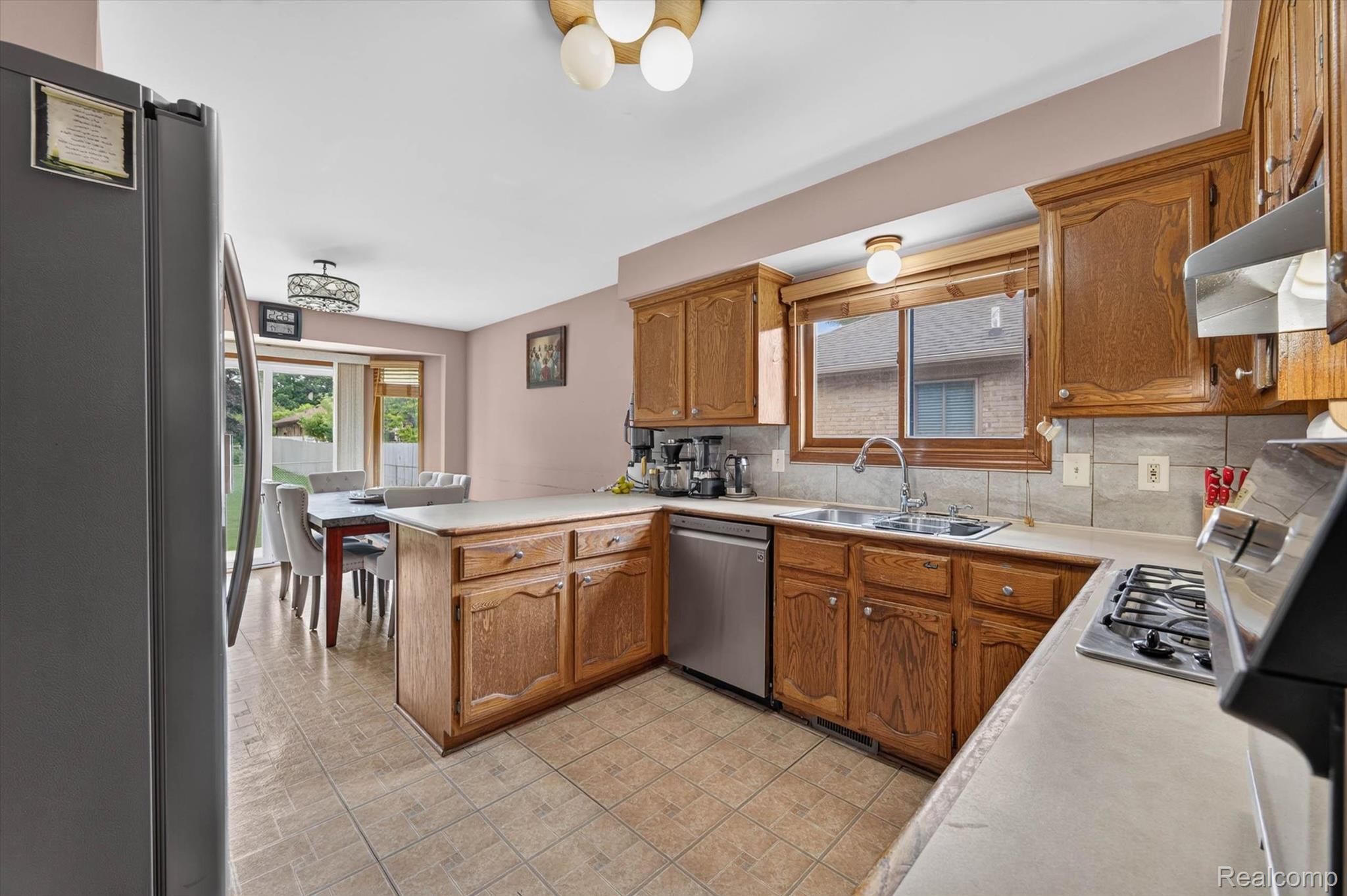 46362 Springhill Drive Utica, MI 48317 - Photo 15 of 59 Kitchen featuring wood cabinetry, stone-finish countertops, and a tile backsplash