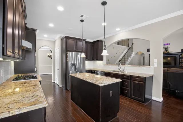 a kitchen with stainless steel appliances granite countertop wooden floors and granite counter tops