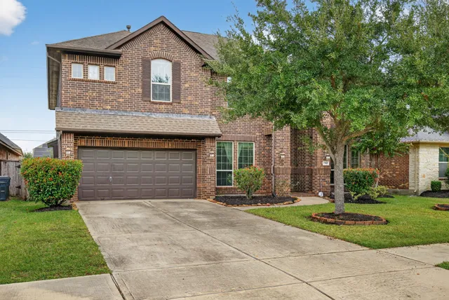 a front view of a house with a yard and garage
