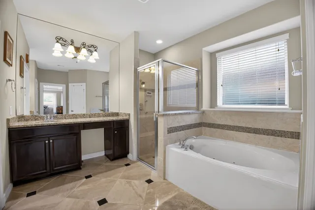 a bathroom with a tub a double vanity sink and a mirror