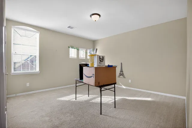 a view of a workspace with furniture and a window