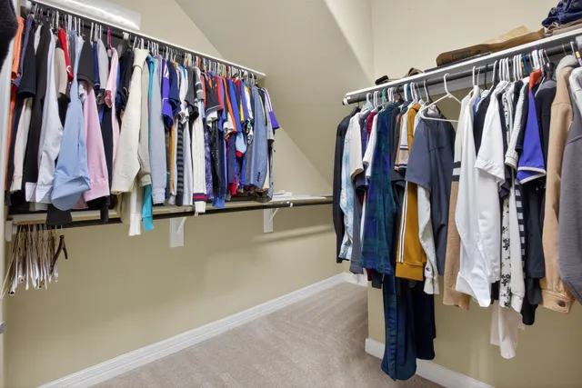 a view of walk in closet with clothes