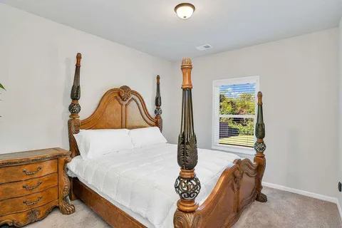 a bed sitting in a bedroom next to a window