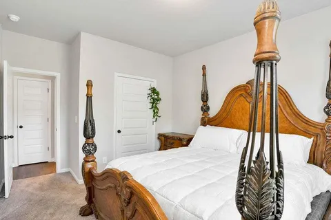 a bedroom with a bed and a painting on the wall