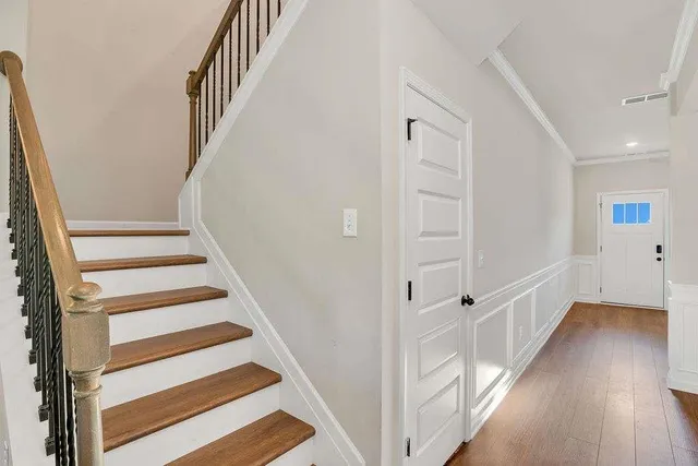a view of staircase with wooden floor and white walls