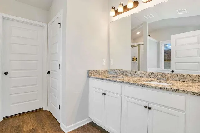 a bathroom with a granite countertop sink and a mirror