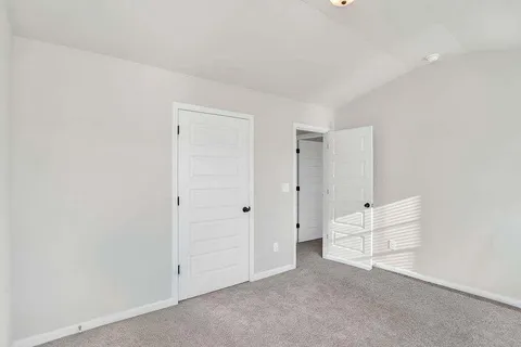 an empty room with white cabinet and mirrors