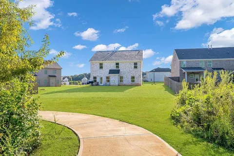 a view of a big house with a big yard and potted plants